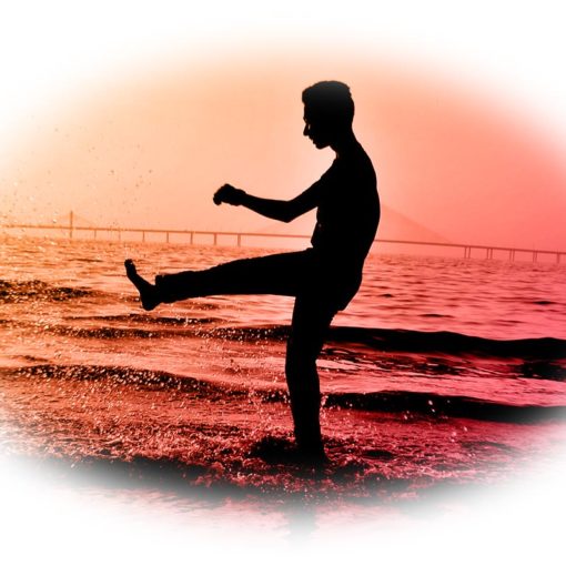 un homme dansant sur la plage à contre-jour