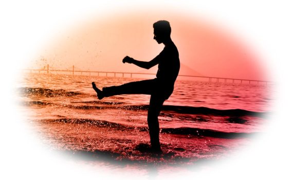 un homme dansant sur la plage à contre-jour